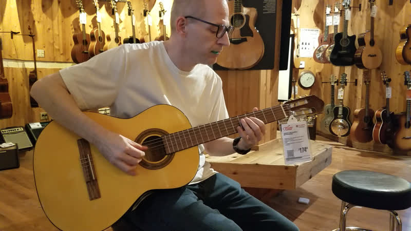 playing a nylon string acoustic guitar
